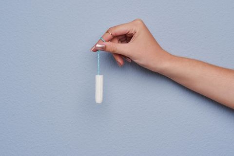 Hand hält Tampon