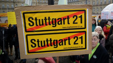 Eine Frau hält bei einer Demo im Jahre 2012 ein durchgestrichenes Stuttgart21-Plakat vor dem Finanzministerium im Neuen Schloss in Stuttgart in die Höhe