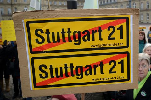 Eine Frau hält bei einer Demo im Jahre 2012 ein durchgestrichenes Stuttgart21-Plakat vor dem Finanzministerium im Neuen Schloss in Stuttgart in die Höhe