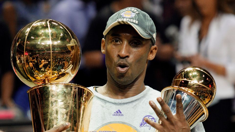 Kobe Bryant hält die Larry O'Brien-Meisterschaftstrophäe und den MVP-Finalpokal