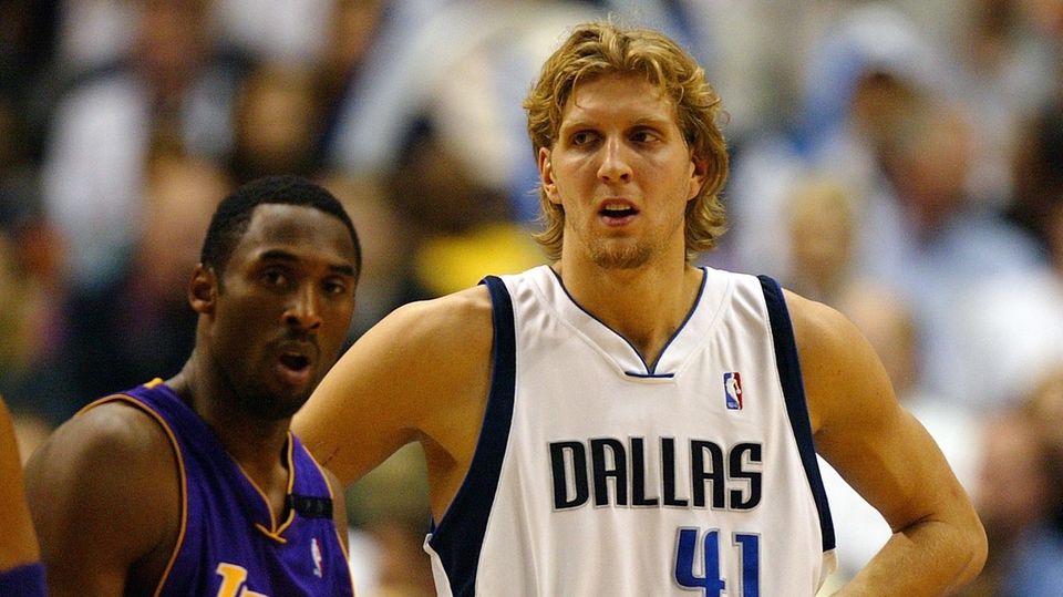Dirk Nowitzki im weißen Dress der Dallas Mavericks und Kobe Bryant im blau-goldenen Lakers-Outfit stehen nebeneinander auf dem s