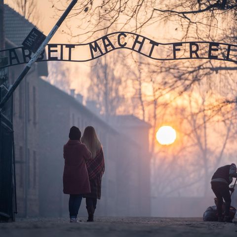 Besucher stehen am frühen Morgen am Tor zum früheren Konzentrationslager Auschwitz