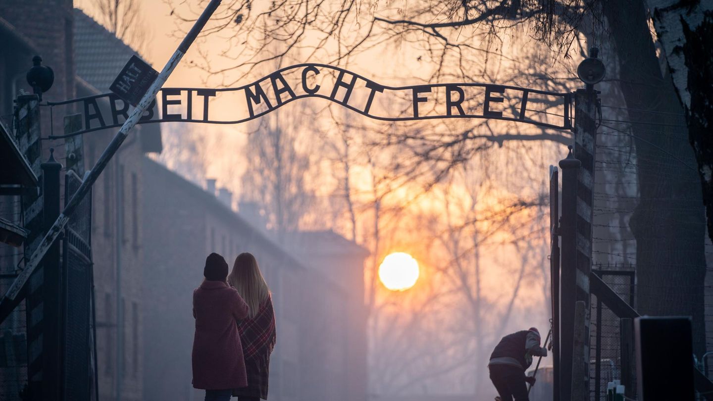 Besucher stehen am frühen Morgen am Tor zum früheren Konzentrationslager Auschwitz
