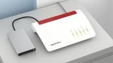 Jetzt wird’s NAS: Die kleine Home-Cloud für schmales Geld  NAS steht für “Network Attached Storages” also ein an das Netzwerk angeschlossenes Speichermedium. Die Daten gelangen nicht mehr über ein USB-Kabel auf die externe Platte, sondern über ein Lan-Kabel oder WLan. Ein kleiner Unterschied mit weitreichenden Folgen. In einem Heimnetzwerk “sieht” jeder Computer diese Festplatten, kann Daten speichern und abrufen. So könnte zum Beispiel jedes Familienmitglied in einem Haushalt seine Daten auf dem NAS sichern, ohne sich eine eigene externe Festplatte kaufen zu müssen. Der oft günstigste Weg zur NAS führt über den USB-Steckplatz am Router. So verwandeln die bessere Router-Modelle wie etwa die Fritzbox 7490 eine USB-Festplatte und sogar USB-Sticks in ein NAS-Laufwerk, das bei den Backup-Programmen als Speicherziel angegeben werden kann. In Sachen Datendurchsatz reichen diese Systeme richtigen Netzwerkfestplatten nicht das Wasser, aber für den Alltagsgebrauch genügen sie völlig.   Vorteil: Günstiger geht es nicht zur NAS.  Nachteil: keine, wenn ohnehin ein entsprechender Router vorhanden ist.