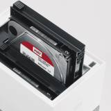 Die Backup-Profiliga: NAS-Systeme für Zuhause  NAS-Systeme sind im Grunde Festplatten in einem Computer ohne Grafikkarte. Und wie beim “normalen” PC entscheidet auch hier die Geschwindigkeit von Prozessor und Festplatten sowie die Größe des Arbeitsspeichers über das Arbeitstempo des NAS-Systems - und den Preis. Einfache Systeme bieten nur eine einzige, meist fest eingebaute, Festplatte von vier Terabyte. Teurere beherbergen zwei oder vier spezielle NAS-Festplatten von bis zu 16 Terabyte. Anders als die Festplatte im PC sind NAS-Laufwerke eigens für die Belastungen im Dauerbetrieb ausgelegt. Per Ethernetkabel an den Router angeschlossen, bilden NAS-Systeme die Profiliga für Backups. Sind mindestens zwei Platten an Bord lassen sich diese zu Klonen (RAID-1) zusammenschalten. Die zweite Festplatte spiegelt dabei immer die erste. Fällt eine Platte aus, ist das Backup auf der zweiten Platte sicher. Die großen Datenspeicher sind wie geschaffen für Videoprojekte und große Mengen an Bild- und Audio-Material. Schöner Nebeneffekt: NAS lassen sich als Medienserver einrichten und zum Beispiel mit dem SmartTV oder Streaming-Lautsprechern verbinden. Der eigene ganz private Streamingdienst sozusagen. Selbst von unterwegs ist die heimische Netzwerkfestplatte in Reichweite. Zu jeder NAS-Software gehört mittlerweile eine eigene Android oder IOS-App. Über die kleinen Anwendungen lässt sich auch ein automatisches Backup der Bilder und Videos auf dem Handy einrichten, sobald das Smartphone in das heimische Netz eingewählt ist. Die wichtigsten NAS-Anbieter sind. WD, Synology, QNAP, Buffalo und Zyxel.   Vorteil: Günstiger großer Speicherplatz, volle Kontrolle, eigener Medienserver, Zugriff über das Web.   Nachteil: technisches Wissen bei Einrichtung und Betrieb erforderlich, Stromverbrauch