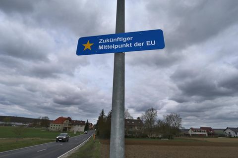 Auf einem an einer Laterne befestigtem Schild im Ortsteil Gadheim ist "Zukünftiger Mittelpunkt der EU" zu lesen