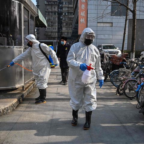 Auf den Straßen von Wuhan versprühen zwei Menschen Desinfektionsmittel