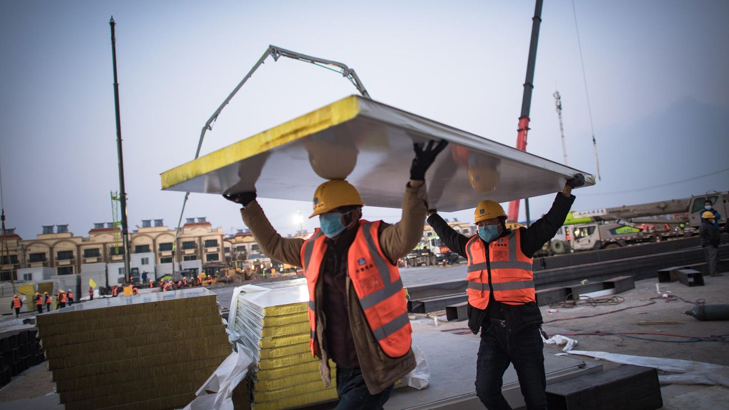 Arbeiter transportieren die Wandpaneele.