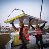 Arbeiter transportieren die Wandpaneele.