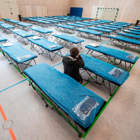 Dutzende Feldbetten stehen in einer Turnhalle auf dem Gelände des Flughafens in Frankfurt bereit