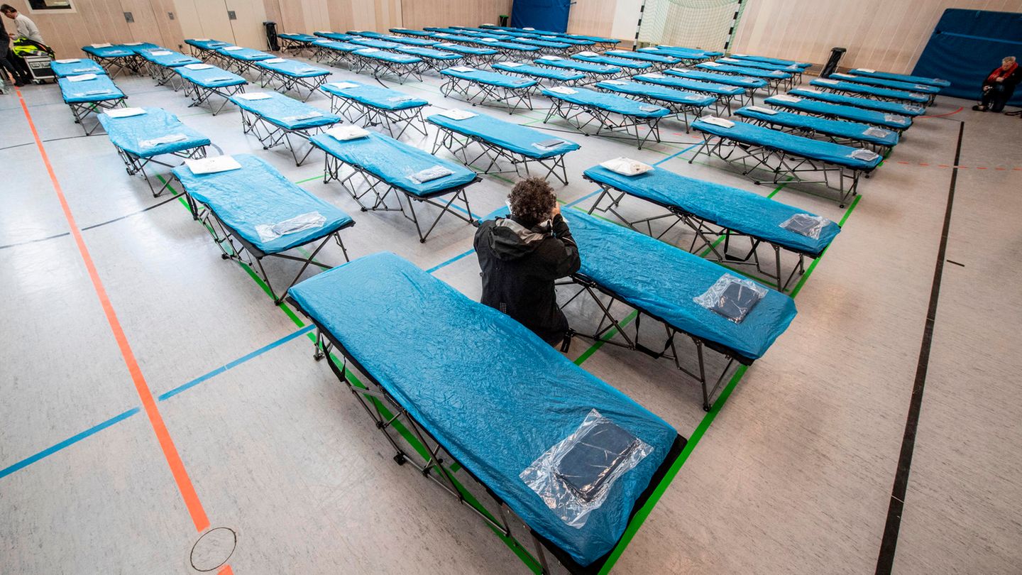 Dutzende Feldbetten stehen in einer Turnhalle auf dem Gelände des Flughafens in Frankfurt bereit