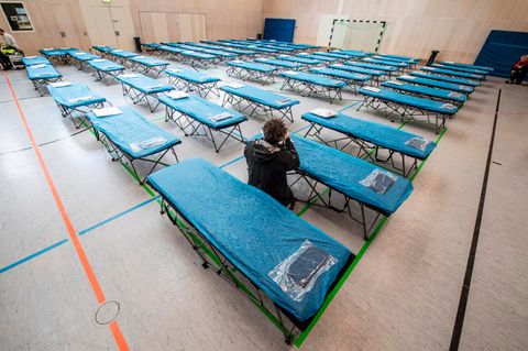 Dutzende Feldbetten stehen in einer Turnhalle auf dem Gelände des Flughafens in Frankfurt bereit