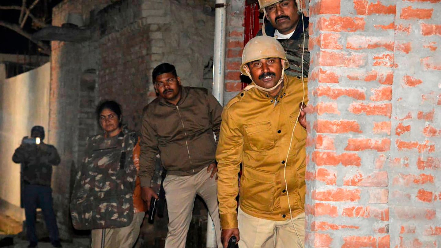 Indien, Kasaria Village: Polizeibeamte gehen während der Mission zur Befreiung von Geiseln in Deckung