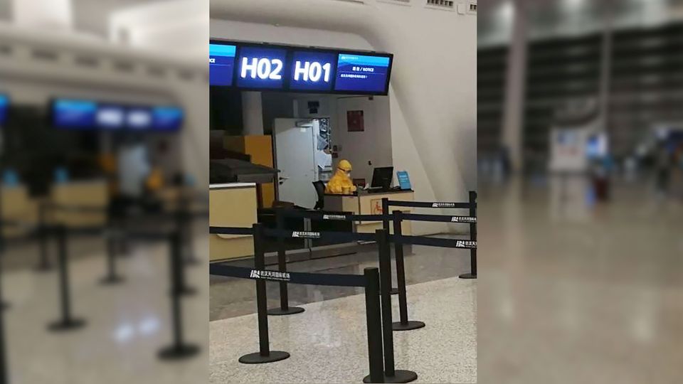Ein Mitarbeiter in Schutzkleidung am Flughafen Wuhan
