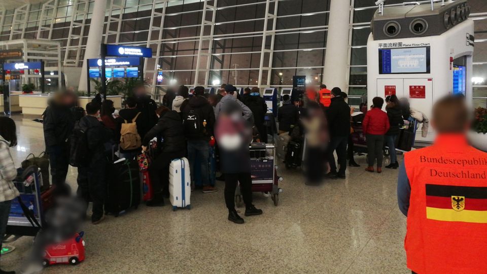 Menschen warten am Flughafen von Wuhan