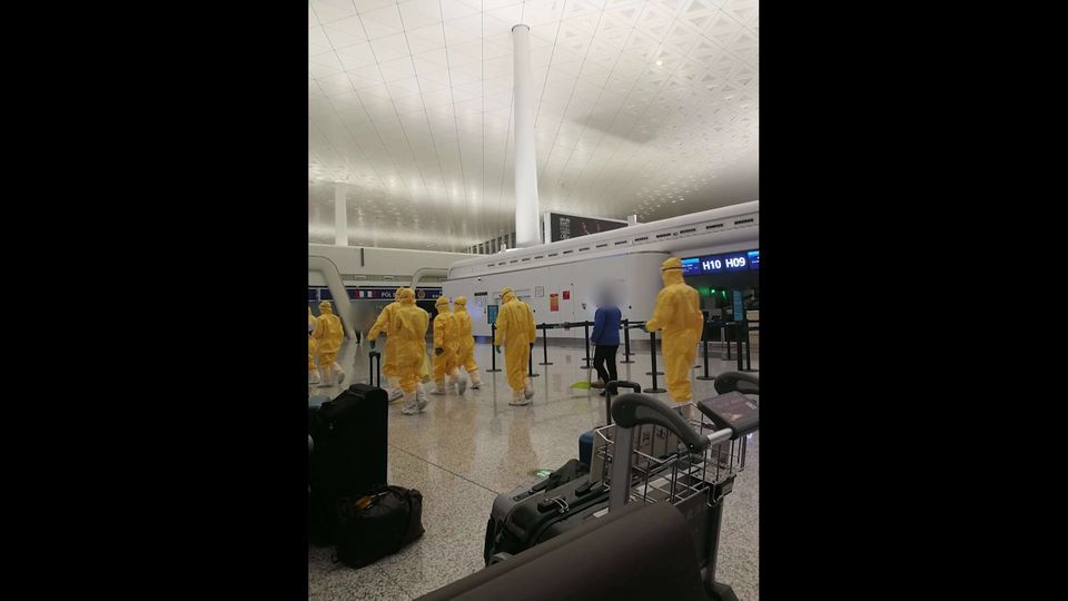 Mitarbeiter in Sicherheitsanzügen am Flughafen von Wuhan