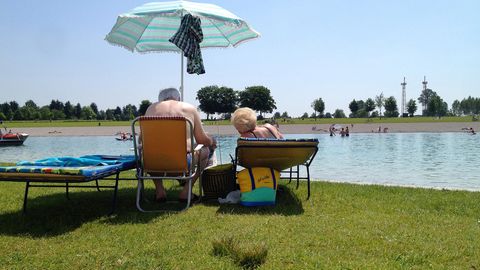 Senioren auf Sonnenliegen mit Sonnenschirm