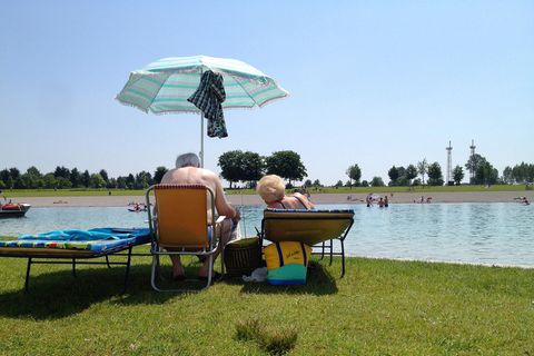 Senioren auf Sonnenliegen mit Sonnenschirm