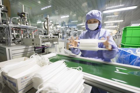 Eine Arbeiterin überprüft Atemschutzmasken in einer Fabrik im Osten Chinas
