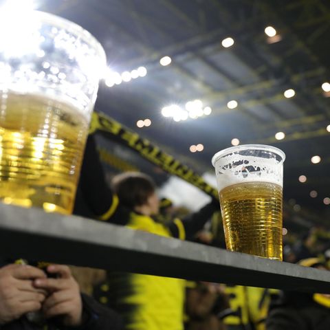 Zwei halbvolle Becher Bier stehen auf einem Geländer im Signal-Iduna-Park von Dortmund