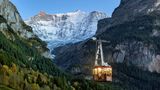 Bild 1 von 11 der Fotostrecke zum Klicken: Luftseilbahn Grindelwald, Schweiz  Tagsüber drängen sich Wanderer mit Rucksäcken oder Rodler in warmer Winterkleidung in den Gondeln der Pfingsteggbahn – am Abend verwandeln sich diese dann in gemütliche kleine Gourmetlokale und laden zum Sky-Dinner. Leise schweben sie in den letzten Sonnenstrahlen den majestätischen Felswänden entgegen oder baumeln unter einem sagenhaft klaren Sternenhimmel.