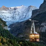 Bild 1 von 11 der Fotostrecke zum Klicken: Luftseilbahn Grindelwald, Schweiz  Tagsüber drängen sich Wanderer mit Rucksäcken oder Rodler in warmer Winterkleidung in den Gondeln der Pfingsteggbahn – am Abend verwandeln sich diese dann in gemütliche kleine Gourmetlokale und laden zum Sky-Dinner. Leise schweben sie in den letzten Sonnenstrahlen den majestätischen Felswänden entgegen oder baumeln unter einem sagenhaft klaren Sternenhimmel.