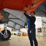 Unter dem Rumpf bringt ein Wissenschafter Instrumente an