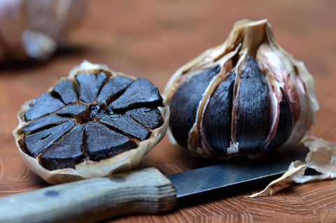 Schwarzer Knoblauch liegt auf einem Tisch