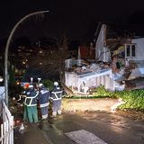 Hamburg: Einsatzkräfte der Feuerwehr und der Bewohner des Hauses begutachten den Schaden an einem Haus. Ein Baum ist infolge des Durchzugs von Sturmtief "Sabine" durch den starken Wind umgekippt und hat im Hamburger Treppenviertel Teile eines Wohnhauses stark beschädigt.