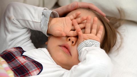 zweijähriges Mädchen reibt sich vor Müdigkeit die Augen