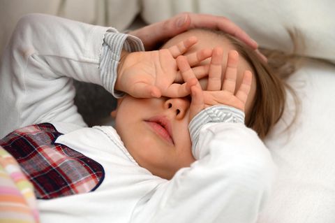 zweijähriges Mädchen reibt sich vor Müdigkeit die Augen