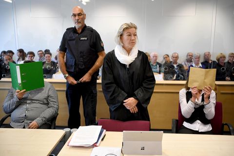 Ein Foto vom Prozessauftakt im vergangenen August: Die beiden Angeklagten verdecken ihre Gesichter