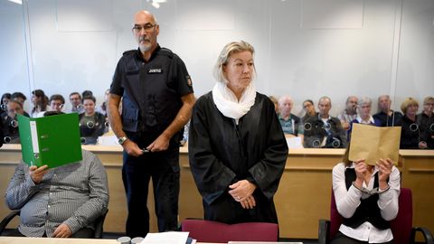 Ein Foto vom Prozessauftakt im vergangenen August: Die beiden Angeklagten verdecken ihre Gesichter
