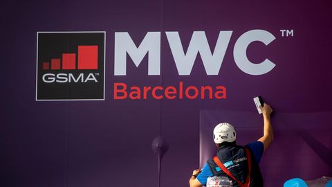Arbeiter putzt Fenster am Ausgang des WMC-Geländes in Barcelona