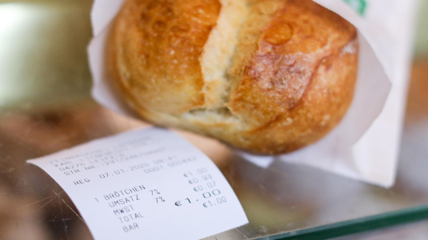 Ein Kassenbon liegt neben einem Brötchen