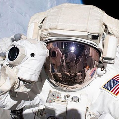 Ein Nasa-Astronaut schwebt mit Fotoapparat und Raumanzug im All