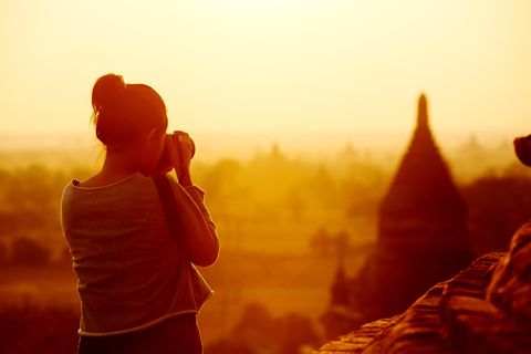 Eine Frau fotografiert eine Tempelanlage in Myanmar