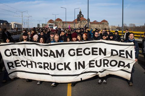 Hinter einem Plakat mit der Aufschrift "Gemeinsam gegen den Rechtsruck in Europa" stehen Demonstranten