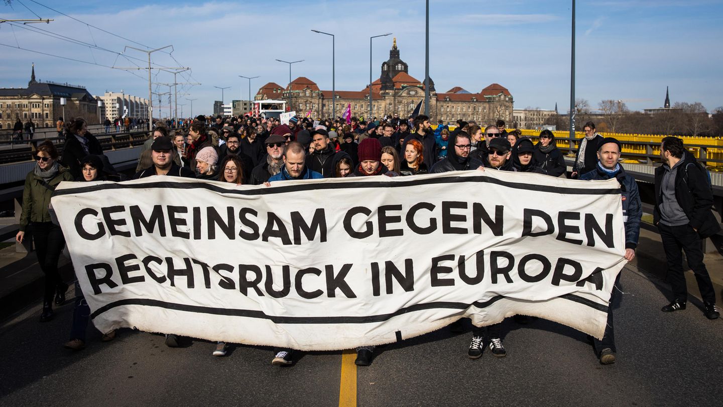 Hinter einem Plakat mit der Aufschrift "Gemeinsam gegen den Rechtsruck in Europa" stehen Demonstranten