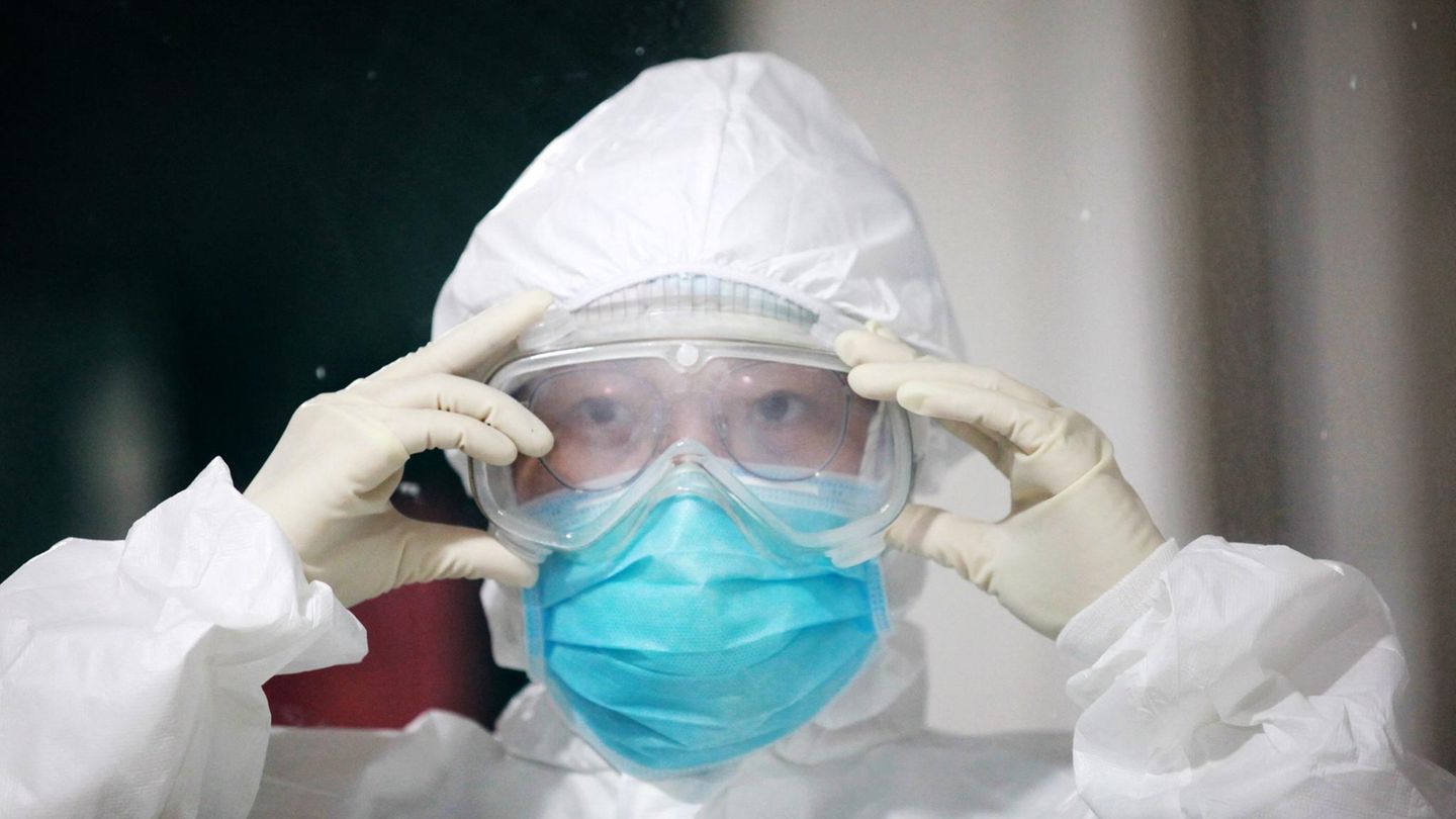 Coronavirus Sars-CoV-2: Eine chinesische Pflegerin legt Schutzkleidung an