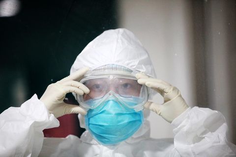 Coronavirus Sars-CoV-2: Eine chinesische Pflegerin legt Schutzkleidung an