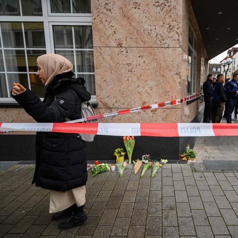 Blumen und Kerzen liegen in der Nähe eines Tatorts in Hanau