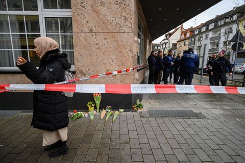 Blumen und Kerzen liegen in der Nähe eines Tatorts in Hanau