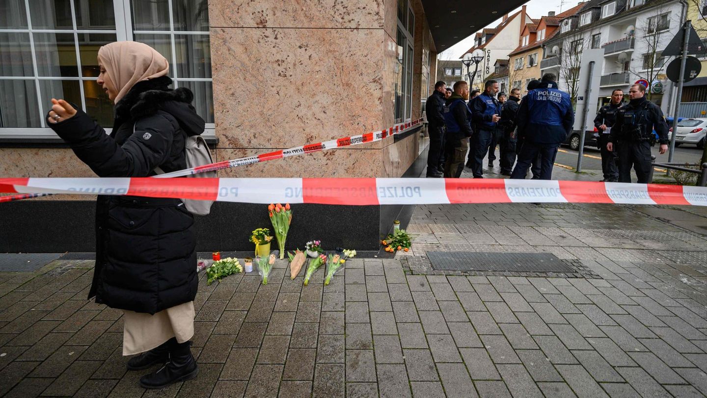 Blumen und Kerzen liegen in der Nähe eines Tatorts in Hanau