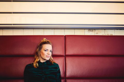 Nora Gantenbrink sitzt auf einem Sofa in einer Hamburger Kneipe
