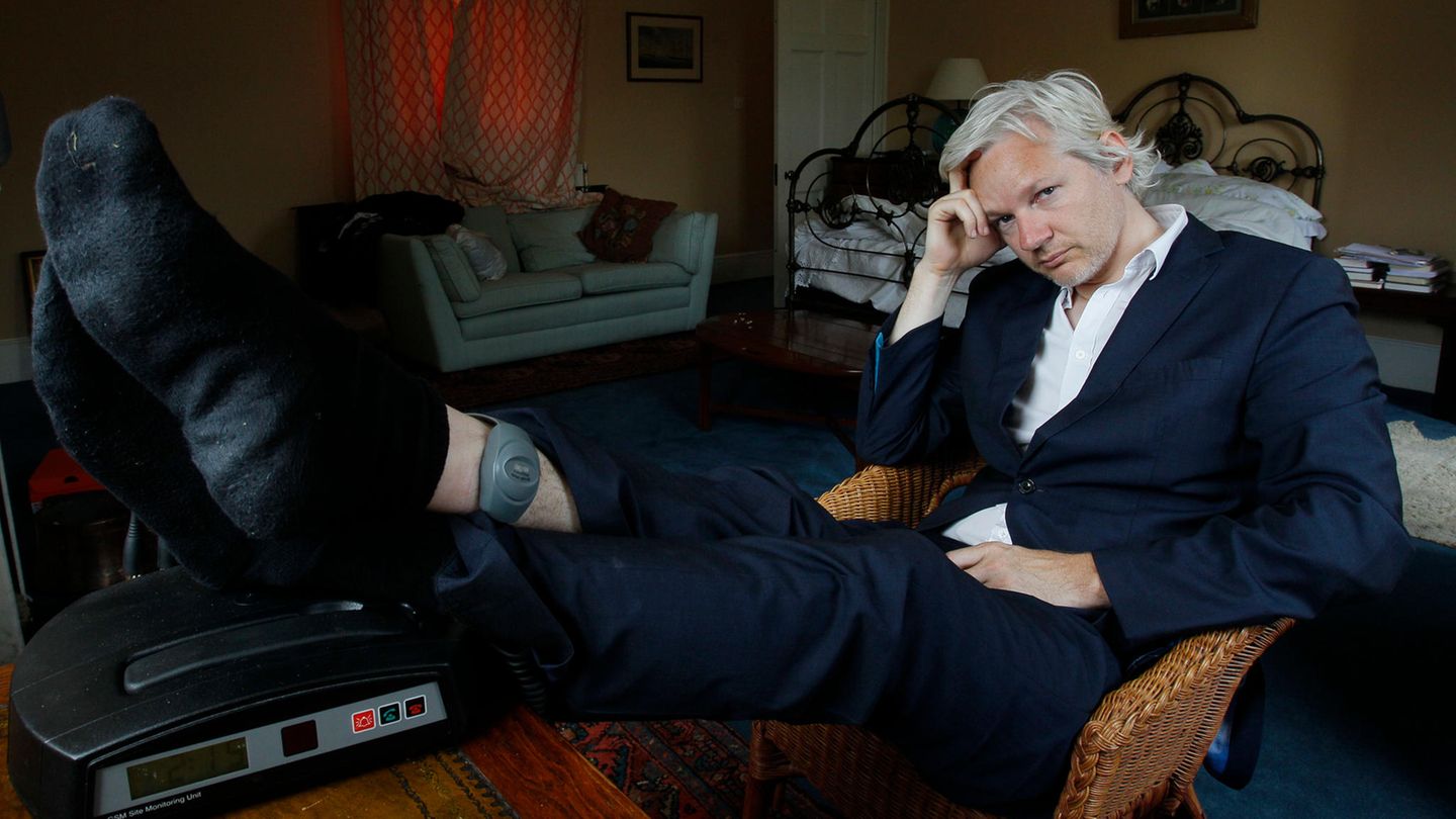 Großbritannien, Bungay: Julian Assange sitzt 2011 mit einer Fußfessel an seinem Knöchel auf einem Stuhl.