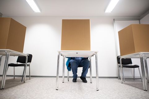 Hamburg: Ein Mann gibt in einer Wahlkabine seine Stimme ab.