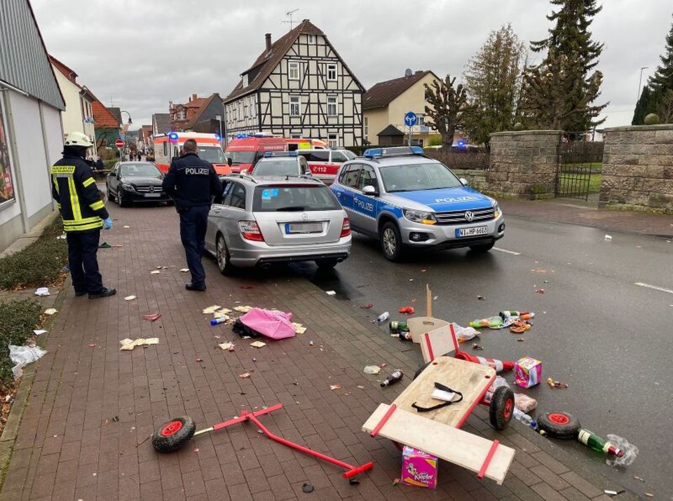 Die Überreste eines Bollerwagen liegen auf dem Gehweg, dahinter das Fahrzeug, das in die Menge gefahren ist Die Überreste eines Bollerwagen liegen auf dem Gehweg, dahinter das Fahrzeug, das in die Menge gefahren ist