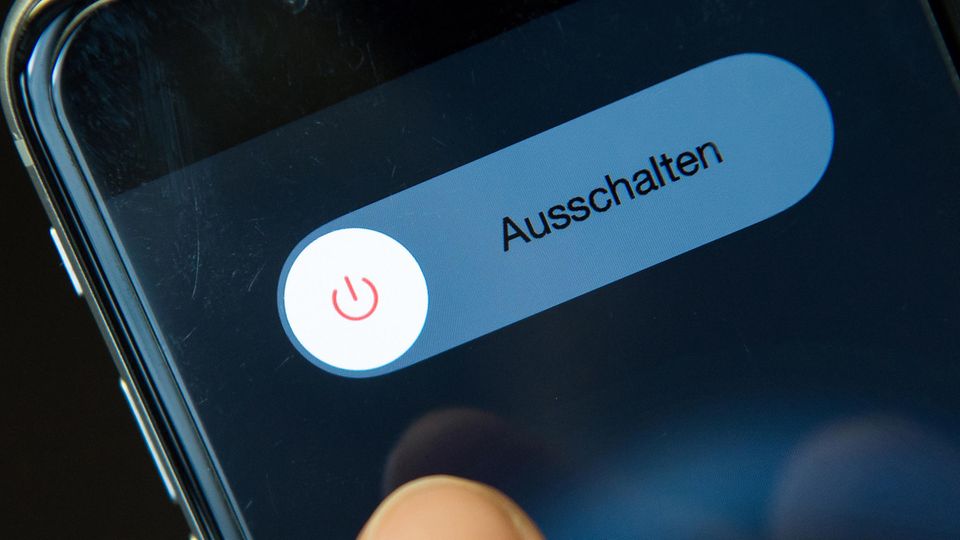 Fastenzeit: Daumen auf einem Smartphone-Display, das den Ausschalten-Button zeigt