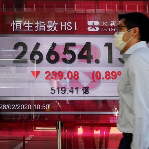 Ein Mann geht an einer Anzeigentafel der Hongkonger Börse vorbei.